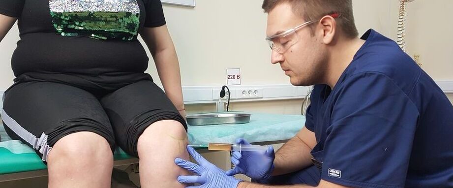 An orthopedist performs an intra-articular injection in the knee joint for osteoarthritis